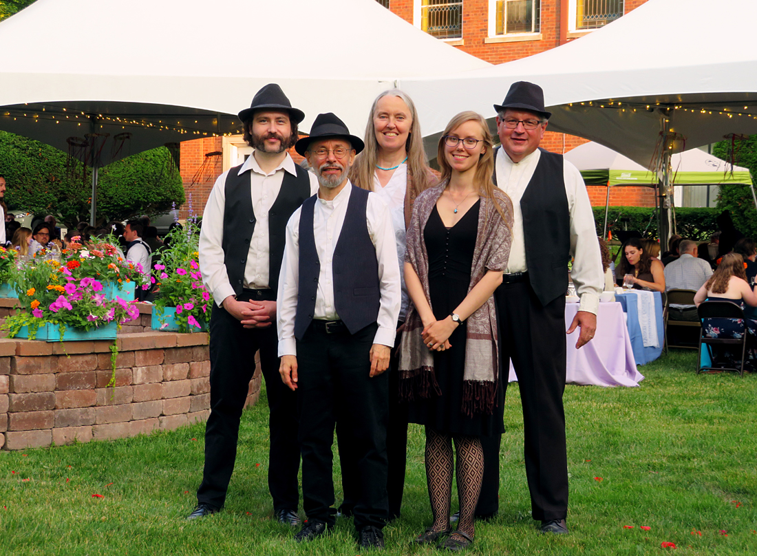 Click for more information about wedding and private party music. Photo of five musicians standing in front of white, peaked-top tents at an outside wedding